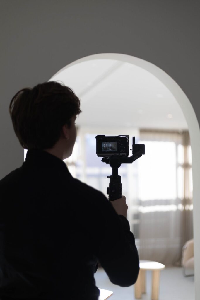 Trouwvideograaf filmt door een witte boog