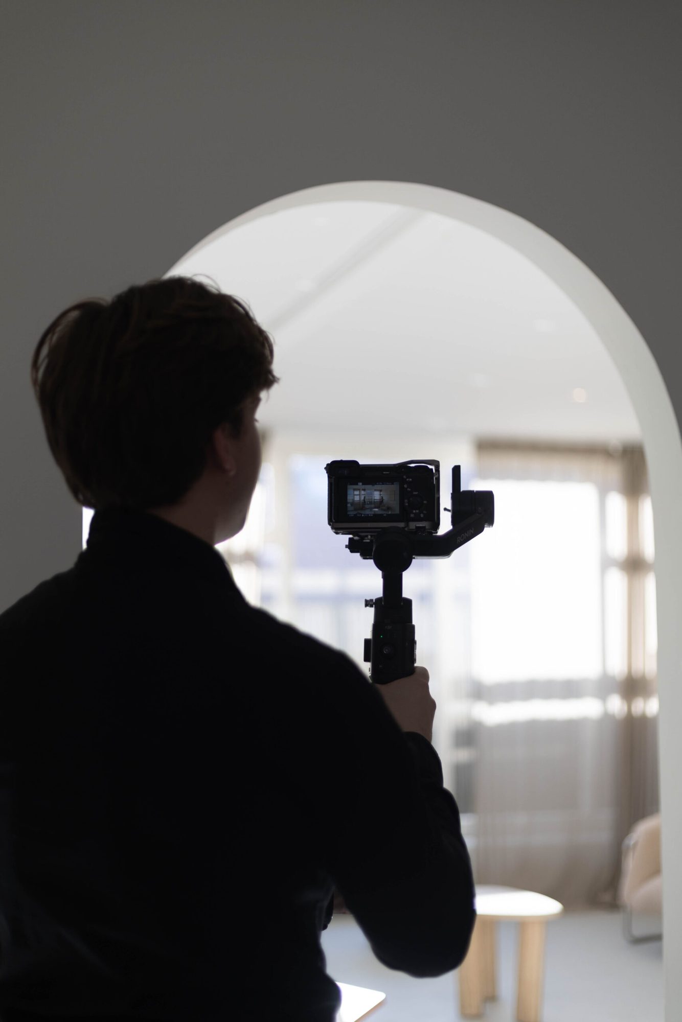 Trouwvideograaf filmt door een witte boog